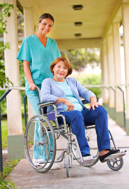 Senior women in wheelchair with nurse in the garden