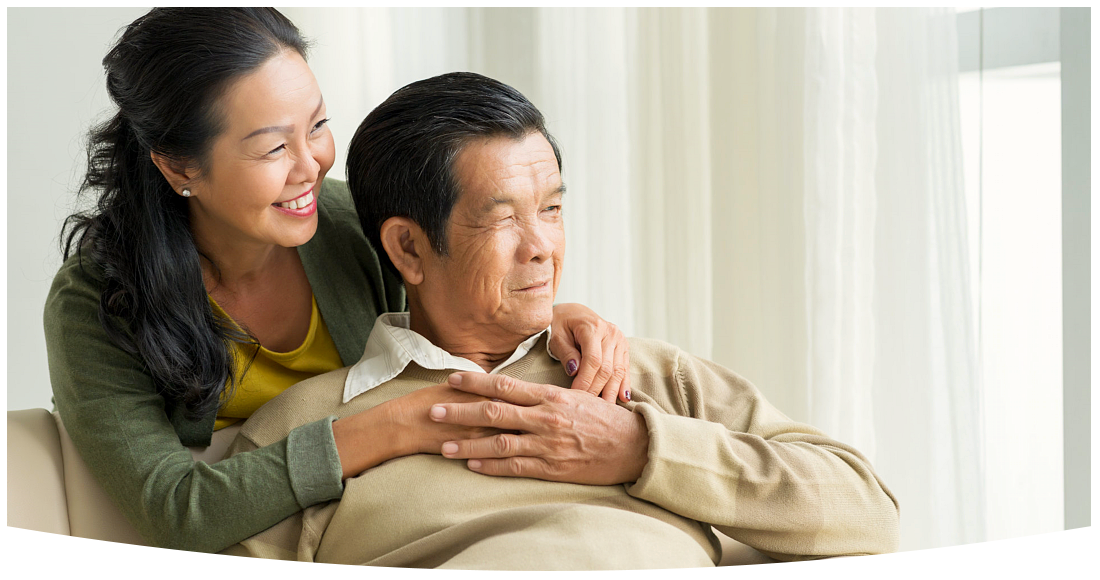 Happy embracing mature couple looking through the window