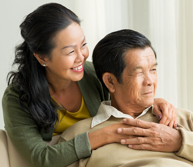 Happy embracing mature couple looking through the window